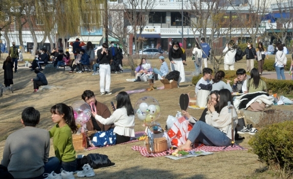 수원 등 경기지역 낮 최고기온이 영상 17도까지 오르는 등 포근한 날씨를 보인 8일 휴일을 맞아 수원화성 방화수류정(訪花隨柳亭) 및 용연(龍淵)을 찾은 시민들이 돗자리를 펴고 앉아 포근한 봄기운을 즐기고 있다. 김시범기자