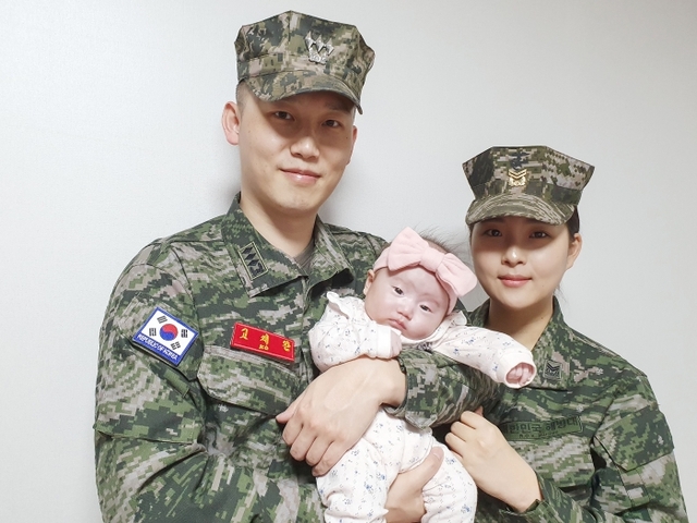 출산장려금을 코로나19 극복을 위한 성금으로 쾌척한 고재완 대위(왼쪽), 김민서 중사 부부가 아이와 함께 기념사진을 찍고 있다. 해병대6여단 제공.
