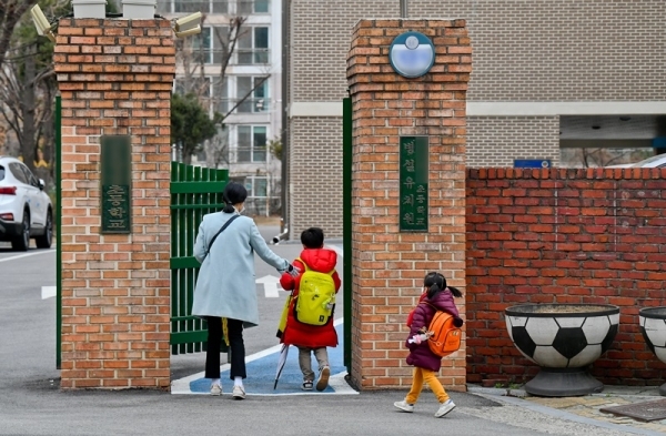 코로나19로 전국의 초,중,고등학교의 개학을 4월로 연기하는 방안을 발표예정인 17일 오전 군포의 한 초등학교에서 돌봄교실로 아이와 부모가 함께 등교하고 있다. 4월로 개학이 연기된다면 맞벌이 부부와 학사일정에 비상이 걸렸다. 윤원규기자