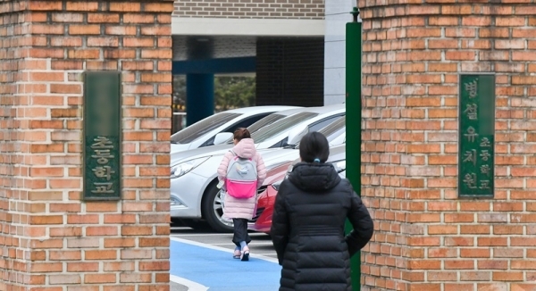 코로나19로 전국의 초,중,고등학교의 개학을 4월로 연기하는 방안을 발표예정인 17일 오전 군포의 한 초등학교에서 돌봄교실로 아이와 부모가 함께 등교하고 있다. 4월로 개학이 연기된다면 맞벌이 부부와 학사일정에 비상이 걸렸다. 윤원규기자