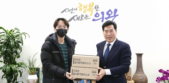 영화배우 나도율 씨(왼쪽)가 김상돈 의왕시장에게 마스크를 전달하고 있다. 의왕시 제공