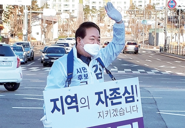 무소속 김선기 예비후보가 시민들을 향해 손을 흔들며 인사를 하고 있다.