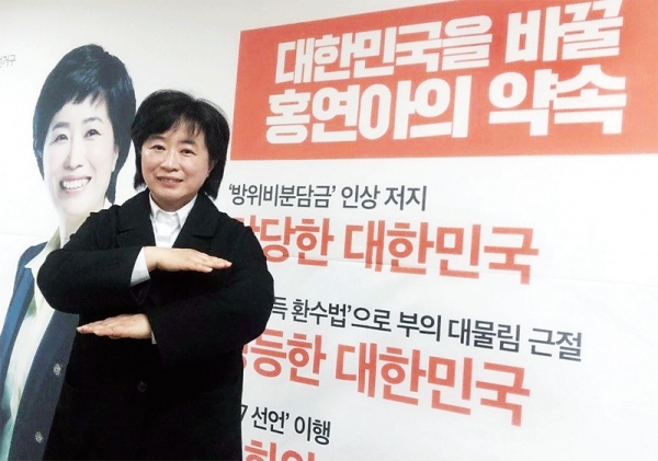 민중당 홍연아 예비후보가 선거포스터 앞에서 포즈를 취하고 있다.