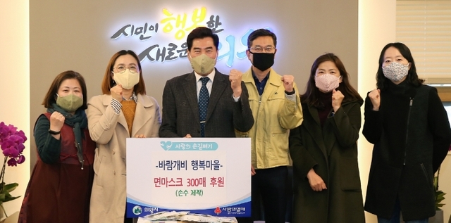 의왕시 바람개비 행복마을단체가 자체적으로 제작한 면 마스크를 김상돈 의왕시장(왼쪽 세 번째)에게 전달한 뒤 함께 사진을 찍고 있다. 의왕시 제공