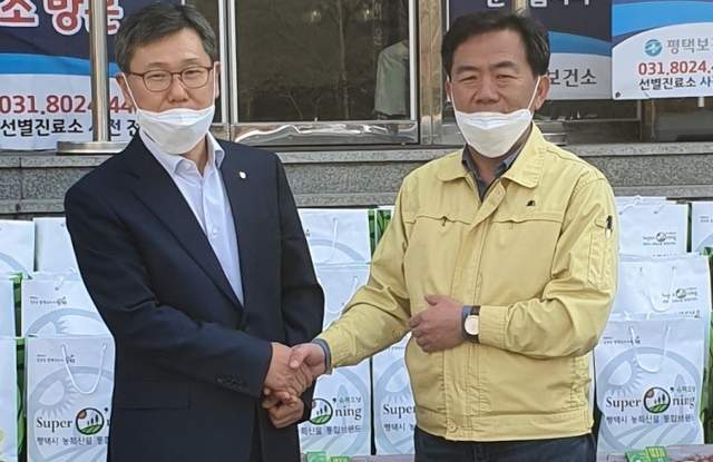 NH농협 평택시지부 박경원 지부장(왼쪽)이 평택보건소 김영호 소장에게 희망꾸러미를 전달하고 있다. NH농협 평택시지부