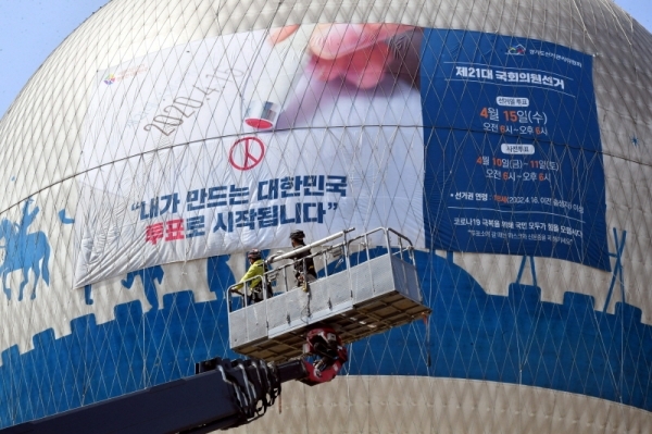 오는 4월15일 실시하는 제21대 국회의원선거를 앞두고 25일 수원시 팔달구 창룡문에서 경기도선거관리위원회 관계자들이 헬륨 기구 플라잉수원에서  유권자들의 투표참여를 독려하는 홍보 현수막을 설치하고 있다.전형민기자