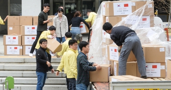 26일 인천시 재난안전대책본부 관계자들이 중국 다롄시에서 도착한 방역복과 마스크등의 지원물품들을 옮기고 있다. 장용준기자