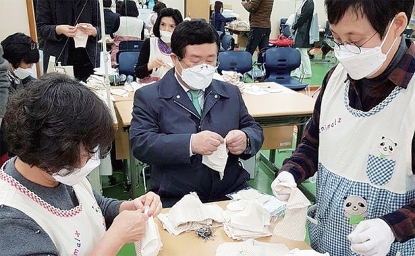 민주당 설훈 후보가 면 마스크 제작 현장을 방문해 자원봉사자들과 함께 마스크를 만들고 있다.