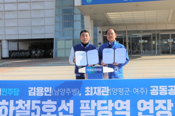 최재관 후보가 지하철5호선 팔당역 연장 공동추진 합의서에 서명하고 이명진 후보와  포즈를 취했다.