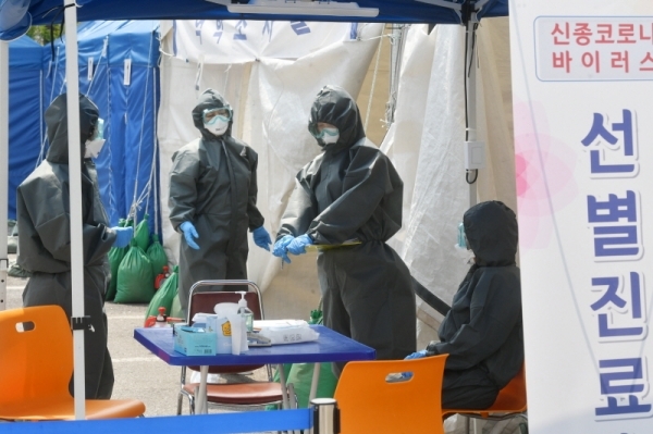 세계 보건의 날인 7일 오전 두달여 동안 코로나19와 사투를 벌여온 성남시 분당구보건소 관계자들이 선별진료소에서 검체를 채취하고 있다. 보건소 관계자는 