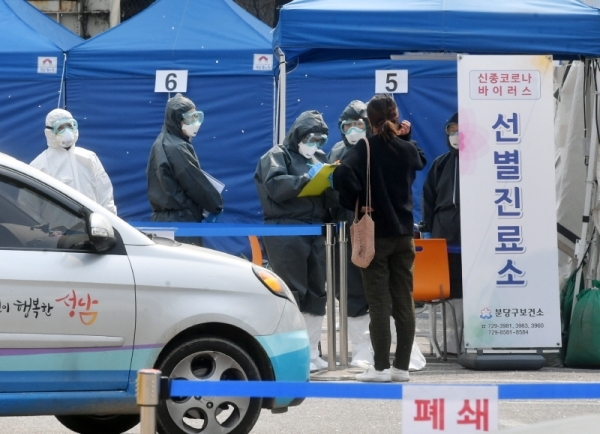 세계 보건의 날인 7일 오전 두달여 동안 코로나19와 사투를 벌여온 성남시 분당구보건소 관계자들이 선별진료소에서 검체를 채취하고 있다. 보건소 관계자는 