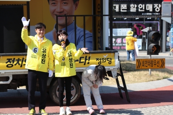 8일 오전 양평읍 로터리에서 열린 유상진 정의당 후보의 거리 유세에서 유후보의 부인 유은정씨가 지지 연설을 하는 동안 딸 하민 양이 지나가는 차량에게 인사를 하고 있다.