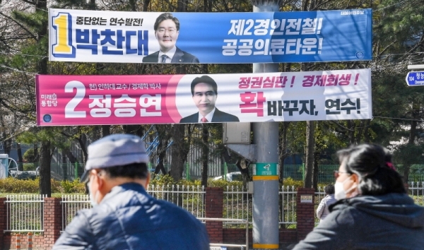 제21대 국회의원 선거(총선) 여론조사 결과 공표 금지일을 하루 앞둔 8일  인천시 연수구 먼우금사거리 유권자들이 연수 갑에 출마한 후보 현수막 앞을 지나고 있다. 장용준기자