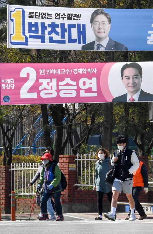 제21대 국회의원 선거(총선) 여론조사 결과 공표 금지일을 하루 앞둔 8일  인천시 연수구 먼우금사거리 유권자들이 연수 갑에 출마한 후보 현수막 앞을 지나고 있다. 장용준기자