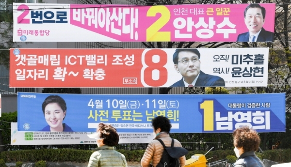 제21대 국회의원 선거(총선) 여론조사 결과 공표 금지일을 하루 앞둔 8일  인천시 연수구 먼우금사거리 유권자들이 연수 갑에 출마한 후보 현수막 앞을 지나고 있다. 장용준기자