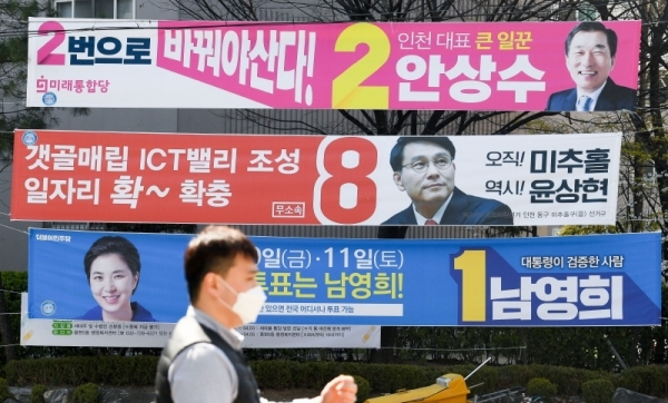 제21대 국회의원 선거(총선) 여론조사 결과 공표 금지일을 하루 앞둔 8일  인천시 연수구 먼우금사거리 유권자들이 연수 갑에 출마한 후보 현수막 앞을 지나고 있다. 장용준기자