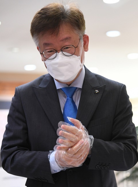 제21대 국회의원 선거 사전투표가 시작된 10일 오전 이재명 경기도지사가 수원시가족여성회관 사전투표소에서 투표를 하기 전 비닐 장갑을 착용하고 있다. 조주현 기자