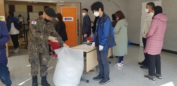 4.15총선 사전투표 첫날인 10일 수원 금곡동 행정복지센터에서 유권자가 투표 시 착용했던 위생장갑을 벗고 있다. 이연우 기자
