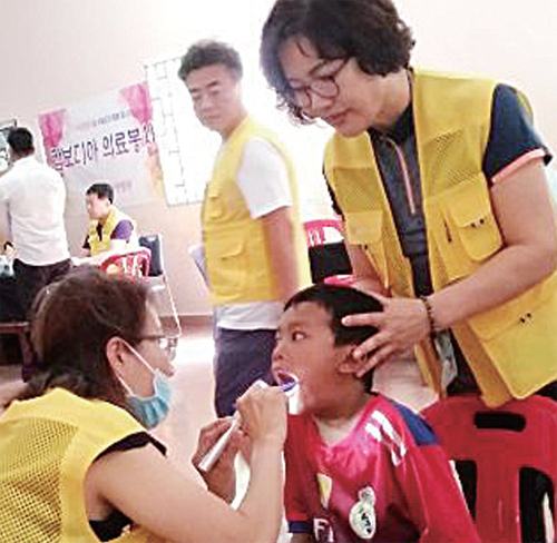 지난 2016년 캄보디아에서 열린 의료봉사에 참가한 간호조무사들이 현지 아동의 건강상태를 확인하고 있다.