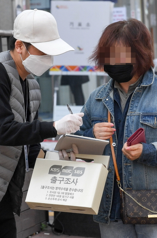 제21대 총선 투표일인 15일 인천시 미추홀구 용현5동의 한 투표소 앞에서 유권자가 출구조사를 하고 있다. 장용준기자