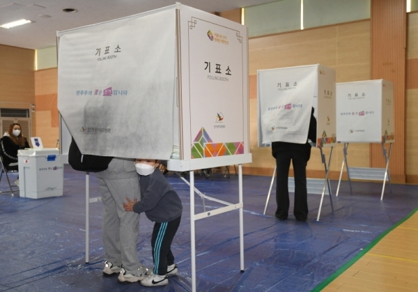 제21대 국회의원 선거가 열린 15일 오전 광명7동 제3투표소에서 엄마를 따라 투표소에 온 어린이가 천진난만하게 장난을 치고 있다.조주현기자