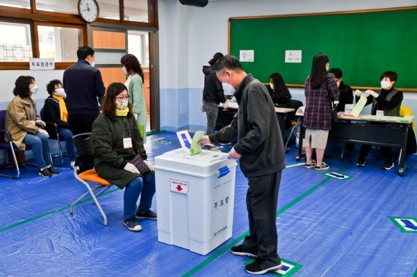제21대 국회의원 선거일인 15일 군포1동 제3투표소가 마련된 군포중학교에서 시민들이 장갑을 낀채 투표하고 있다. 윤원규기자