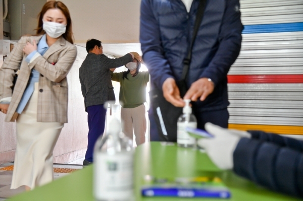 제21대 국회의원 선거일인 15일 군포1동 제3투표소가 마련된 군포중학교에서 시민들이 투표 준비를 하고 있다. 코로나19로 투표를 위해선 발열체크와 손소독 후 비닐장갑을 끼고 투표를 할 수 있다. 윤원규기자