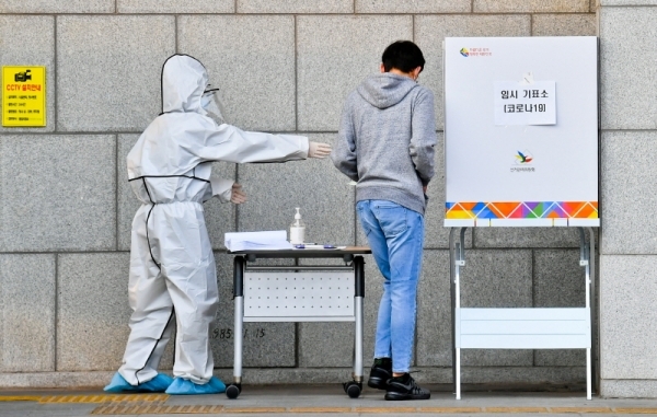 제21대 국회의원선거가 열린 15일 오후 수원시청 야외 코로나19 임시 기표소에서 수원시 자가격리자가 투표하고 있다. 윤원규기자