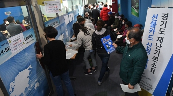 경기도재난기본소득 현장신청이 시작된 20일 오전 인계동행정복지센터 접수처에서 시민이 재난기본소득 현장신청을 하고 있다. 조주현기자