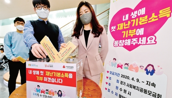 경기도 재난기본소득의 기부물결이 이어지고 있는 가운데 23일 오후 수원시 팔달구청에서 직원들이 코로나19 피해 돕기 신청서를 모금함에 넣고 있다. 경기도사회복지공동모금회와 수원시가 진행하는 ‘착한나눔 캠페인’은 가까운 행정복지센터에서 신청서를 작성해 모금함에 제출하면 재난기본소득 지원금이 자동으로 형편이 어려운 이웃에게 기부된다. 윤원규기자