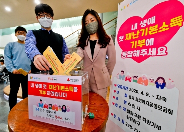 경기도 재난기본소득의 기부물결이 이어지고 있는 가운데 23일 오후 수원시 팔달구청에서 직원들이 코로나19 피해 돕기 신청서를 모금함에 넣고 있다. 경기도사회복지공동모금회와 수원시가 진행하는 ‘착한나눔 캠페인’은 가까운 행정복지센터에서 신청서를 작성해 모금함에 제출하면 재난기본소득 지원금이 자동으로 형편이 어려운 이웃에게 기부된다. 윤원규기자