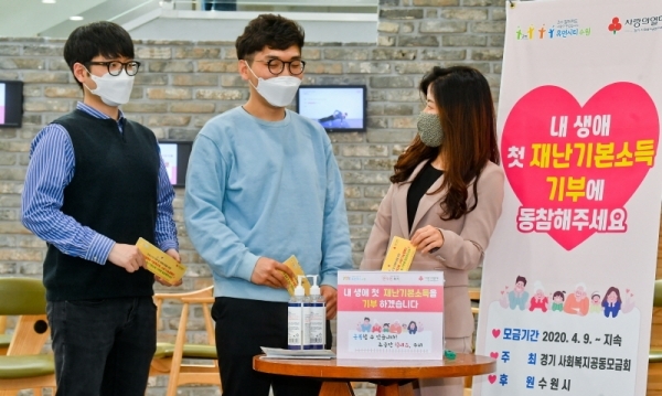 경기도 재난기본소득의 기부물결이 이어지고 있는 가운데 23일 오후 수원시 팔달구청에서 직원들이 코로나19 피해 돕기 신청서를 모금함에 넣고 있다. 경기도사회복지공동모금회와 수원시가 진행하는 ‘착한나눔 캠페인’은 가까운 행정복지센터에서 신청서를 작성해 모금함에 제출하면 재난기본소득 지원금이 자동으로 형편이 어려운 이웃에게 기부된다. 윤원규기자