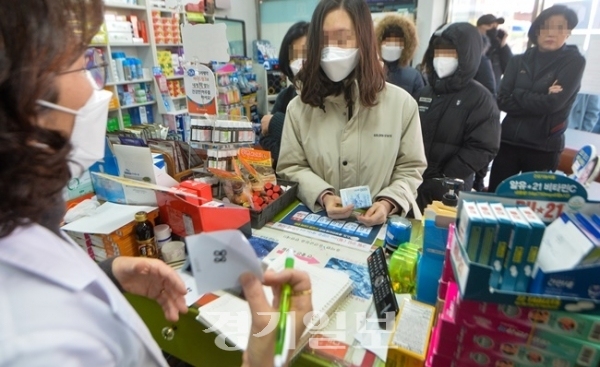 코로나19 확산 이후 공적마스크를 구매하기 위해 사람들이 길게 줄을 서고 있다. 경기일보DB