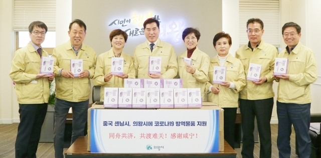 김상돈 의왕시장(왼쪽 네번째)과 윤미근 의왕시의회의장(왼쪽 다섯번째) 등이 중국 후베이성 셴닝시에서 보내 온 열 체온계를 전달받고 기념촬영을 하고 있다. 사진=의왕시 제공