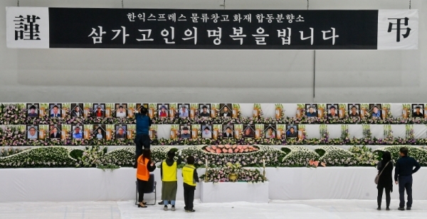 30일 오후 이천시 서희청소년문화센터에 마련된 이천 물류창고 공사장 화재 합동분향소에서 희생자의 영정사진을 설치하고 있다. 윤원규기자