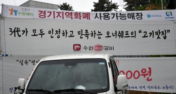 경기도 재난기본소득이 본격적으로 사용되면서 도내 소상공인들의 지역화폐 유치전이 치열하다. 5일 경기도내 각 업종별 상점들이 다양한 모양의 현수막 등을 내걸고 지역화폐 가맹점임을 홍보하고 있다.  김시범ㆍ전형민기자