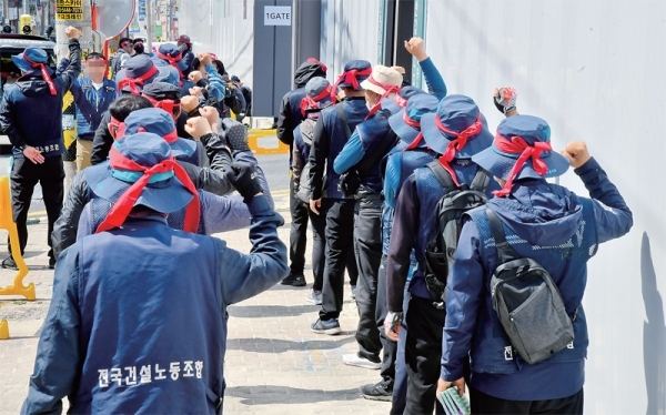 6일 오전 수원 팔달8구역 재개발 공사현장 1게이트 앞에서 민주노총 전국건설노조 경기남부타워크레인지부와 한국노총 전국연합노조 경기본부 조합원들이 각각타워크레인 기사 채용을 요구하며 농성을 벌이고 있다. 윤원규기자