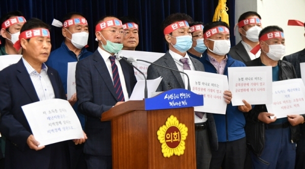 경기도상인연합회 이충환 회장과 시장상인 등 참석자들이 7일 경기도의회 브리핑룸에서 농협 하나로마트 재난기본소득 지역화폐 사용을 반대하는 기자회견을 하고 있다.전형민기자