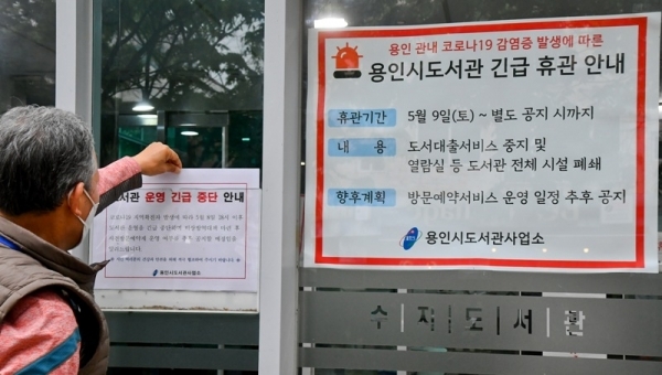 9일 오후 용인 수지도서관에서 직원이 긴급휴관 안내문을 붙이고 있다. 용인시는 이태원 클럽을 다녀온 20대가 코로나19 확진 판정을 받으면서 부분 개장했던 공공도서관 17개와 공공 수영장 6개를 11일까지 긴급 휴관한다. 윤원규기자