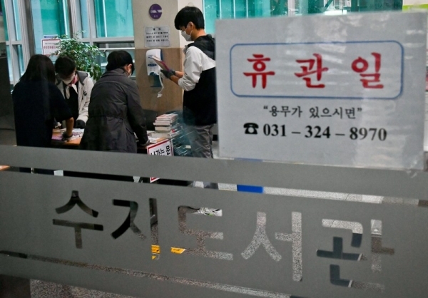 9일 오후 용인 수지도서관에서 직원들이 무인반납함에 반납된 책들을 소독제로 청소하고 있다. 용인시는 이태원 클럽을 다녀온 20대가 코로나19 확진 판정을 받으면서 부분 개장했던 공공도서관 17개와 공공 수영장 6개를 11일까지 긴급 휴관한다. 윤원규기자