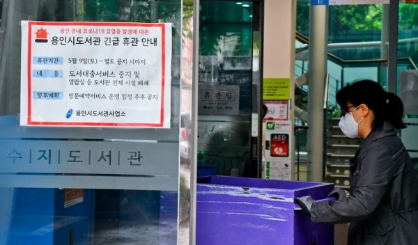 9일 오후 용인 수지도서관에서 직원이 무인반납함에 반납된 책들을 옮기고 있다. 용인시는 이태원 클럽을 다녀온 20대가 코로나19 확진 판정을 받으면서 부분 개장했던 공공도서관 17개와 공공 수영장 6개를 11일까지 긴급 휴관한다. 윤원규기자