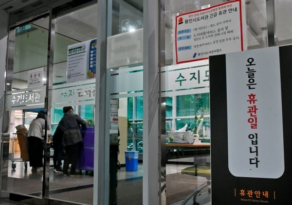9일 오후 용인 수지도서관에서 직원들이 무인반납함에 반납된 책들을 소독제로 청소하고 있다. 용인시는 이태원 클럽을 다녀온 20대가 코로나19 확진 판정을 받으면서 부분 개장했던 공공도서관 17개와 공공 수영장 6개를 11일까지 긴급 휴관한다. 윤원규기자
