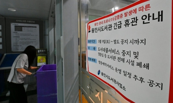 9일 오후 용인 수지도서관에서 직원들이 무인반납함에 반납된 책들을 소독제로 청소하고 있다. 용인시는 이태원 클럽을 다녀온 20대가 코로나19 확진 판정을 받으면서 부분 개장했던 공공도서관 17개와 공공 수영장 6개를 11일까지 긴급 휴관한다. 윤원규기자