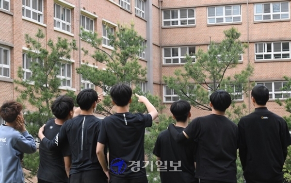 지난 11일 오후 경기도 용인시 한 고등학교 앞에서 고3 학생들이 창문 너머로 교실을 바라보고 있다. 조주현 기자