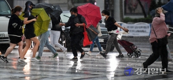 인천을 비롯한 수도권지역에 천둥과 돌풍을 동반한 비가 내린 18일 오후 우산을 받처 든 시민이 밤같이 어두워진 인천버스종합터미널 사거리 횡단보도에서 발걸음을 재촉하고 있다. 장용준기자