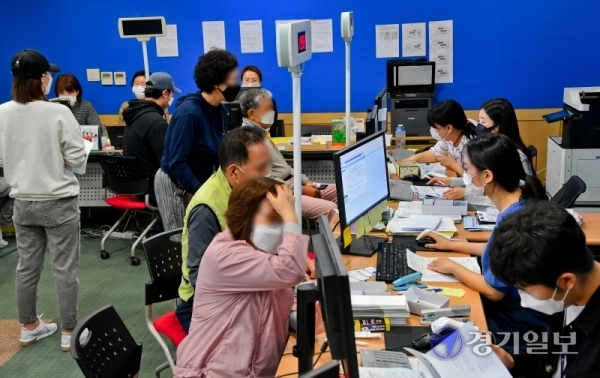 긴급재난지원금 현장 신청 접수 첫날인 18일 오전 수원시 인계동행정복지센터에서 시민들이 긴급재난지원금을 신청하고 있다. 이날 경기도내 각 주민센터마다 신청자들이 한꺼번에 몰리면서 일부 시ㆍ군에서 오전 한때 전산 오류로 인한 신청 중단사태가 발생하는 등 혼란이 빚어졌다. 윤원규기자