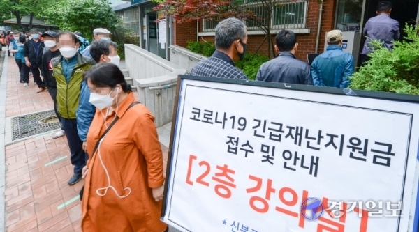 코로나19 관련 긴급재난지원금 오프라인 신청 접수 첫날인 18일 오전 인천시 서구 연희동 주민센터 앞에 길게 늘어선 시민들이 신청 순서를 기다리고 있다. 행정안전부는 이날 오전 9시부터 읍면동 주민센터 등에서 긴급재난지원금 지역사랑상품권과 선불카드 오프라인 신청을 받으며 마스크 5부제와 동일한 요일제로 신청할 수 있다고 밝혔다.  장용준기자
