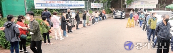 긴급재난지원금 현장 신청 첫날인 18일 오전 시민이 인천시 서구 연희동 행정복지센터 앞에 길게 늘어서서 순서를 기다리고 있다. 장용준기자