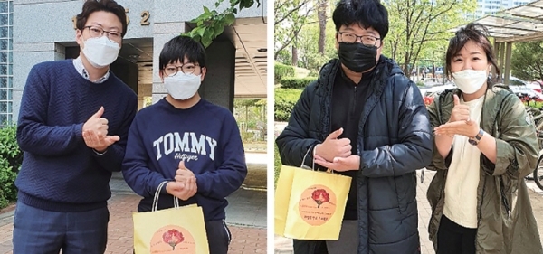 안양중학교 교사들이 특수학급 학생들을 만나 선물 꾸러미를 전달한 후 ‘덕분에챌린지’ 포즈를 하고 있다.