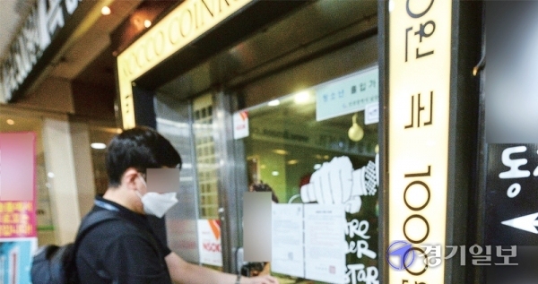 인천시가 코인 노래방에 2주간 집합금지 명령을 내린 21일 남동구 관계자들이 구월동 로데오거리의 한 코인 노래방 출입문에 집합금지 조치 안내문을 붙이고 있다. 장용준기자